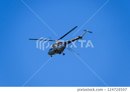 A helicopter of agricultural aviation is flying in the blue sky. A helicopter of agricultural aviation is flying in the blue sky. 124728507