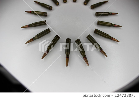 Circle Of Live Ammunition Laid Out On White Surface Circle Of Live Ammunition Laid Out On White Surface 124728873
