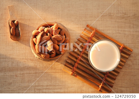 A bowl of almond milk surrounded by assorted nuts placed on a rustic wooden background A bowl of almond milk surrounded by assorted nuts placed on a rustic wooden background 124729350