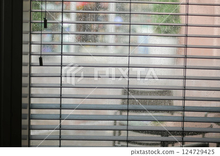 A lovely and cozy view looking out through blinds on a rainy day featuring outdoor seating A lovely and cozy view looking out through blinds on a rainy day featuring outdoor seating 124729425