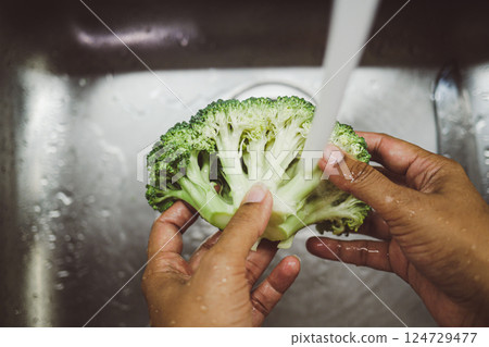 It is essential to wash fresh broccoli thoroughly using running water for optimal cleanliness 124729477
