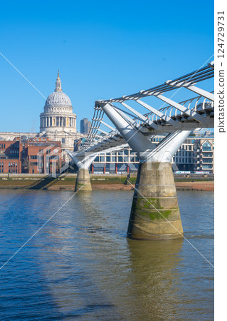The iconic Millennium Bridge stretches across the River Thames, with St. Paul's Cathedral majestically rising in the background against a clear blue sky. The iconic Millennium Bridge stretches across the River Thames, with St. Paul's Cathedral majestically rising in the background against a clear blue sky. 124729731