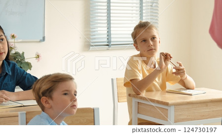 Caucasian smart student listening teacher explaining about classwork. Pedagogy. 124730197