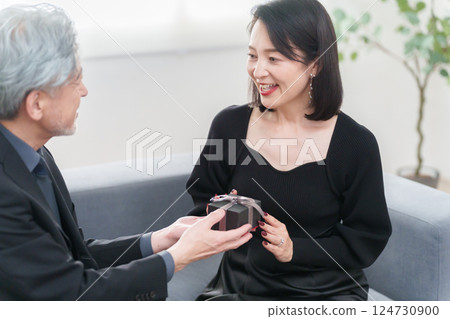 A woman receiving a gift from a man (couple) 124730900
