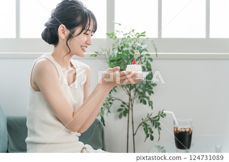 A woman who eats a snack / snack cake at home A woman who eats a snack / snack cake at home 124731089