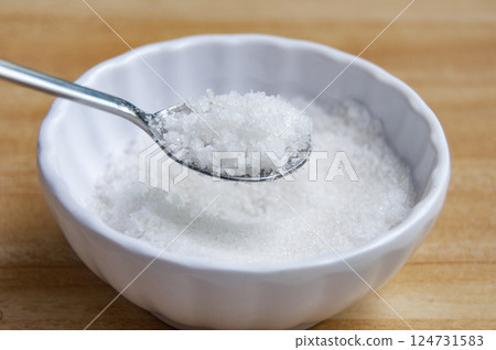 Side view of a spoon filled with coarse salt with customizable space for text or ideas. Side view of a spoon filled with coarse salt with customizable space for text or ideas. 124731583