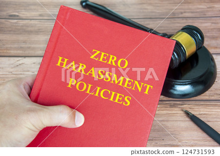 Hand holding Zero Harassment Policies book with gavel background. Harassment free concept Hand holding Zero Harassment Policies book with gavel background. Harassment free concept 124731593