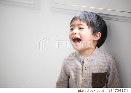A little boy laughing with his mouth wide open 124734174