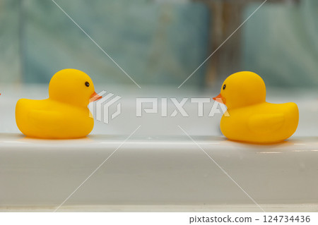 Two Classic Yellow Rubber Ducks Beautifully Floating Together in Calm and Cheerful Waters 124734436