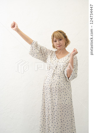 A pregnant woman standing and posing 124734447