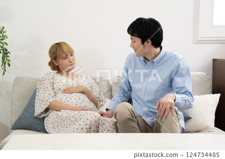 Pregnant couple relaxing in the living room 124734485