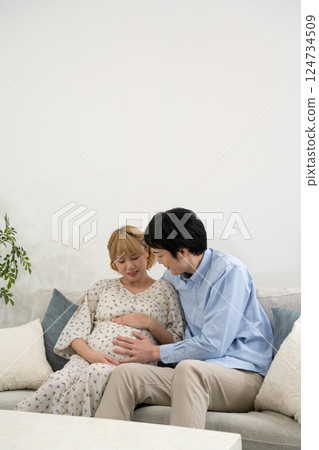 Pregnant couple relaxing in the living room 124734509