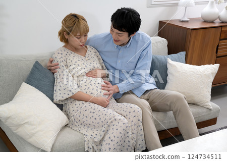 懷孕的夫婦在客廳放鬆 懷孕的夫婦在客廳放鬆 124734511