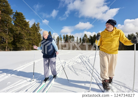 Cheerful Caucasian couple on ski trip in pine forest area. Cheerful Caucasian couple on ski trip in pine forest area. 124734827