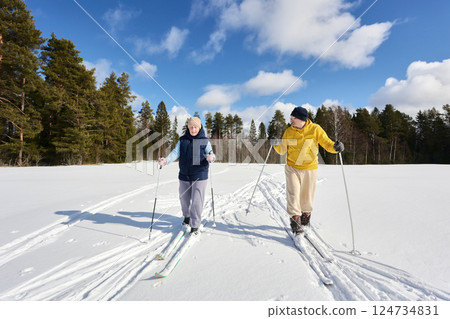 Middle aged couple skiing near forest on sunny winter day. 124734831