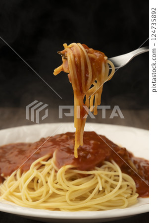 Pick up spaghetti with instant pasta sauce using a fork 124735892