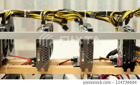 A close-up shot of a video card used in a mining rig, showcasing the details of the graphics card, including memory chips and cooling fans. cryptocurrency mining, GPU technology 124736084