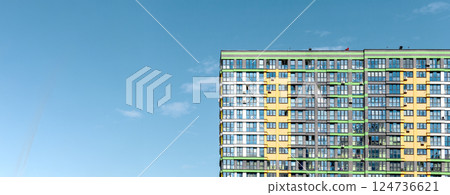 Building with modern facade. Tall high rise apartment with clear blue sky, sunny metropolitan 124736621