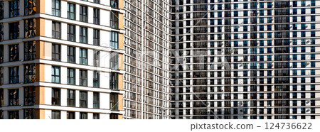 Building with modern facade. Highrise condominium with multiple balcony pattern, window design and 124736622