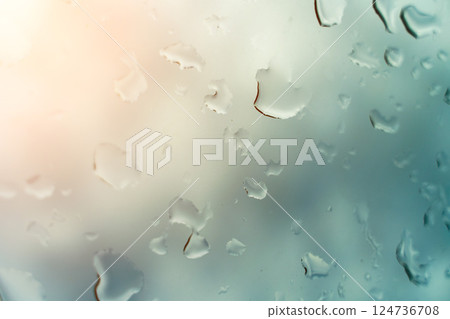 Water drops on glass against blue sky, rainy season concept. Window view background screensaver Water drops on glass against blue sky, rainy season concept. Window view background screensaver 124736708