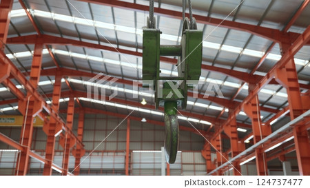 Closeup of swivel chain hook crane of electric hoist in factory workshop, pullersSwivel chain hook equipment for pullers, industry lifting machine 124737477