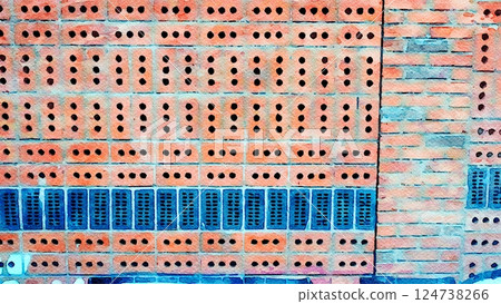 Wall made of perforated bricks arranged horizontally and vertically. 124738266