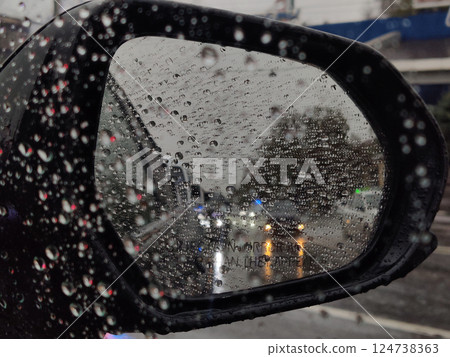 a view from inside car to raindrops on car mirror a view from inside car to raindrops on car mirror 124738363