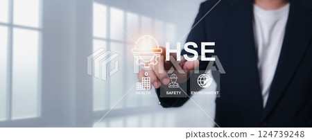 HSE, Health safety environment concept, Safety and protection in industrial work, Accident.Standard safe industrial work and industrial, Engineer Standing holding a hat with the HSE letter icon. HSE, Health safety environment concept, Safety and protection in industrial work, Accident.Standard safe industrial work and industrial, Engineer Standing holding a hat with the HSE letter icon. 124739248