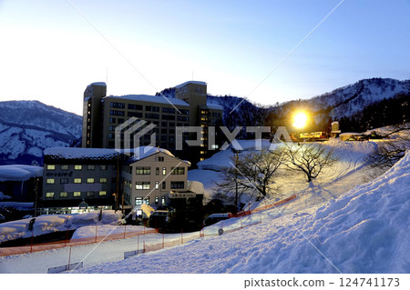 隨著太陽下山，滑雪中心和度假村公寓周圍的燈光亮起。 124741173