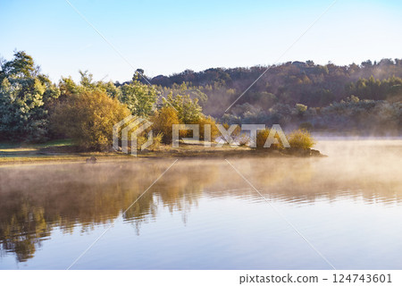 Morning fog over autumn lake water Morning fog over autumn lake water 124743601