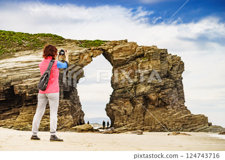 Woman with camera at Cathedral Beach, Galicia Spain. 124743716