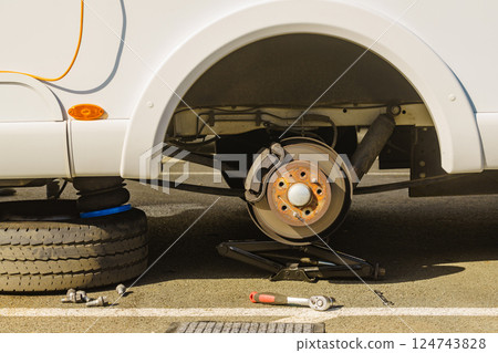 Car in service repairing. Detail of wheel assembly on automobile 124743828