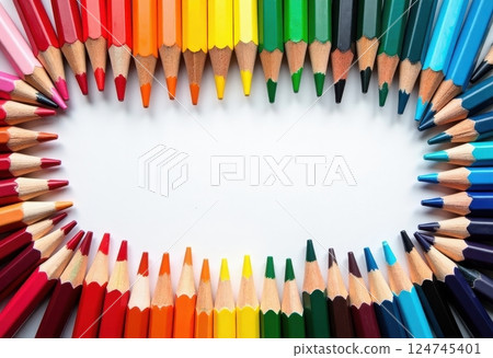 This image showcases a vibrant array of colored pencils arranged in a heart shape on a white background. The pencils are positioned with their tips pointing inward, creating a striking visual effect.  124745401