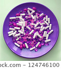 Pink medical pills and herb capsules on violet plate 124746100