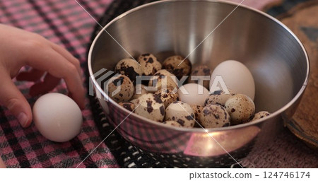 Boiled quail eggs prepared for cooking using fresh organic eggs with hand reaching for one available in a bowl Boiled quail eggs prepared for cooking using fresh organic eggs with hand reaching for one available in a bowl 124746174