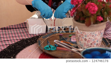 Joyful activity of coloring eggs with vibrant hues and creative designs for Easter eggs celebration and decoration in a cozy setting 124746178