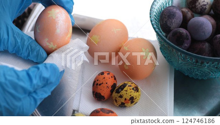Colorful Easter eggs and quail eggs showing vibrant pearl paint and delicate designs while being prepared for Easter celebrations in a festive setting Colorful Easter eggs and quail eggs showing vibrant pearl paint and delicate designs while being prepared for Easter celebrations in a festive setting 124746186