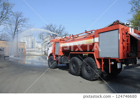 Water cannon of a firetruck shooting a high-velocity stream of water during training 124746680