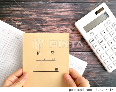 女人的手拿著桌子上的薪水信封 124746816