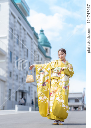 A young woman wearing a long-sleeved kimono 124747087