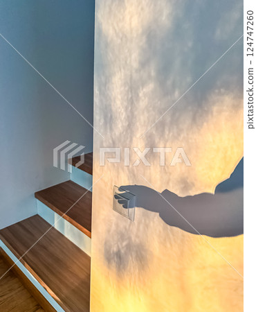 Shadow Hand Turning on Light Switch by Stairs, Interior Scene, Light and Shadow Play, Home. High quality photo Shadow Hand Turning on Light Switch by Stairs, Interior Scene, Light and Shadow Play, Home. High quality photo 124747260