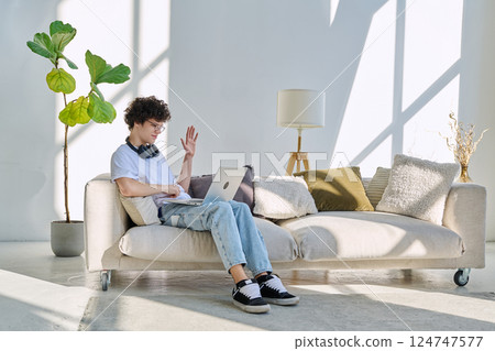 Young man using laptop for video call, online chat conference sitting at home 124747577
