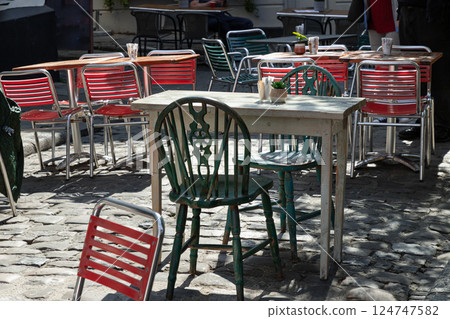 Sunlight shine through Wooden table and Green metal chairs outside a cafe on street. 124747582