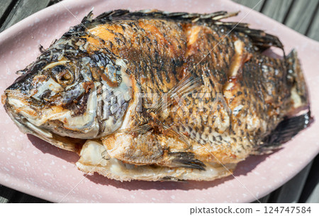Delicious Deep Fried Whole Tilapia Fish on Ceramic fish plate. Delicious Deep Fried Whole Tilapia Fish on Ceramic fish plate. 124747584