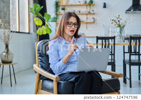 Middle aged woman working remotely, video conference, using laptop 124747596