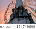 The Belgian Infantry Memorial with the giant Ferris wheel known as The View on background at dusk in Brussels, Belgium with a beautiful sunset sky 124749609