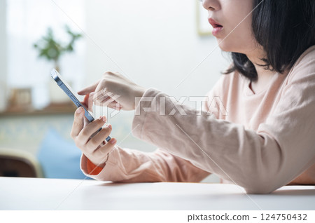 A woman watching a smartphone 124750432