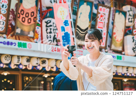 A woman taking a video in Shinsekai, Osaka 124751127