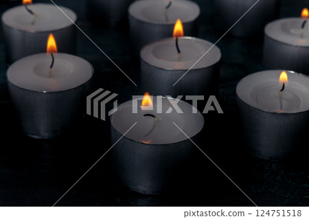 Tea light candles on a dark background, many lights in the dark 124751518