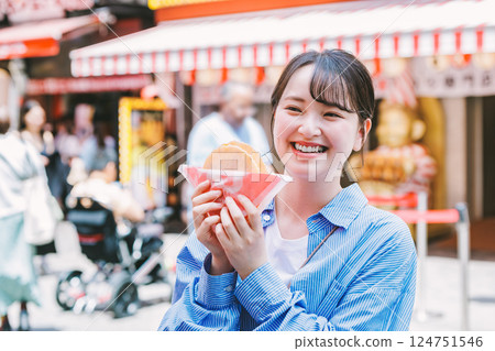 一位女士在大阪道頓堀吃著名的章魚線 124751546